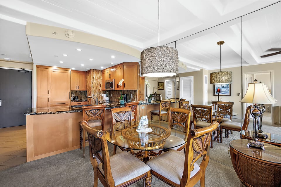 Gather around the spacious open-plan kitchen and dining area, where elegant pendant lighting and warm wood tones create the perfect setting for your memorable meals together.