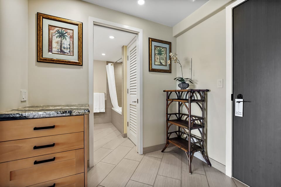 Breezy island style welcomes you with tropical art and fresh linens. Your private bath awaits beyond the louvered door, while a graceful shelf holds a delicate orchid for that personal touch.