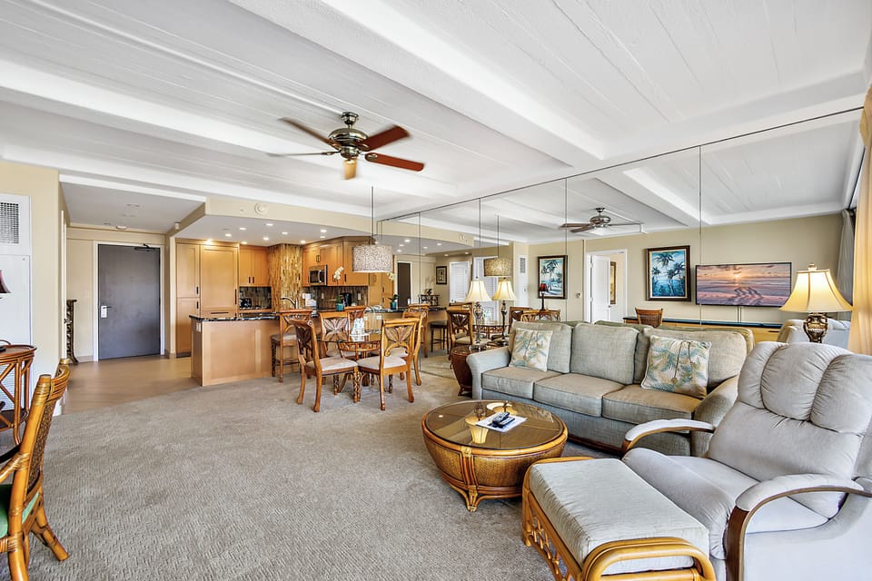 Unwind in your spacious open-concept living area, where coastal elegance meets comfort with stylish furnishings, vaulted ceilings, and seamless flow to your dining space and fully-equipped kitchen.