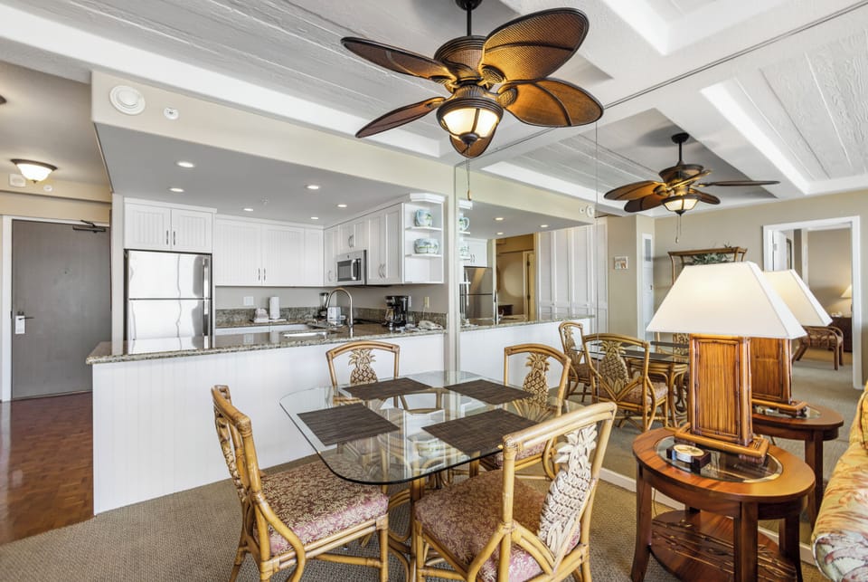 Your spacious open-concept living area features a fully equipped kitchen, comfortable dining space, and tropical-style décor with elegant ceiling fans to keep you cool and relaxed.