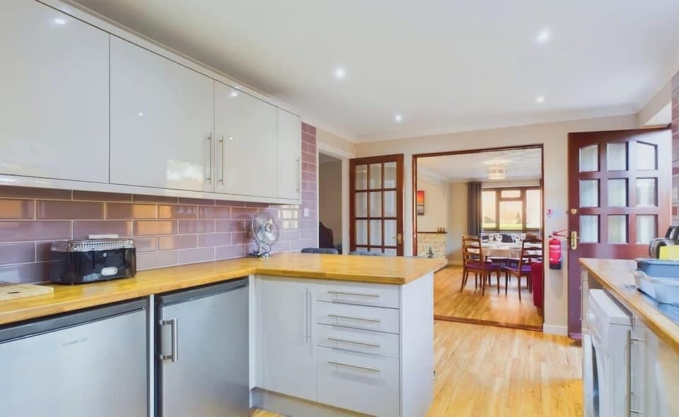 This spacious kitchen offers ample room for food prep, including an oven, hob, and dishwasher.