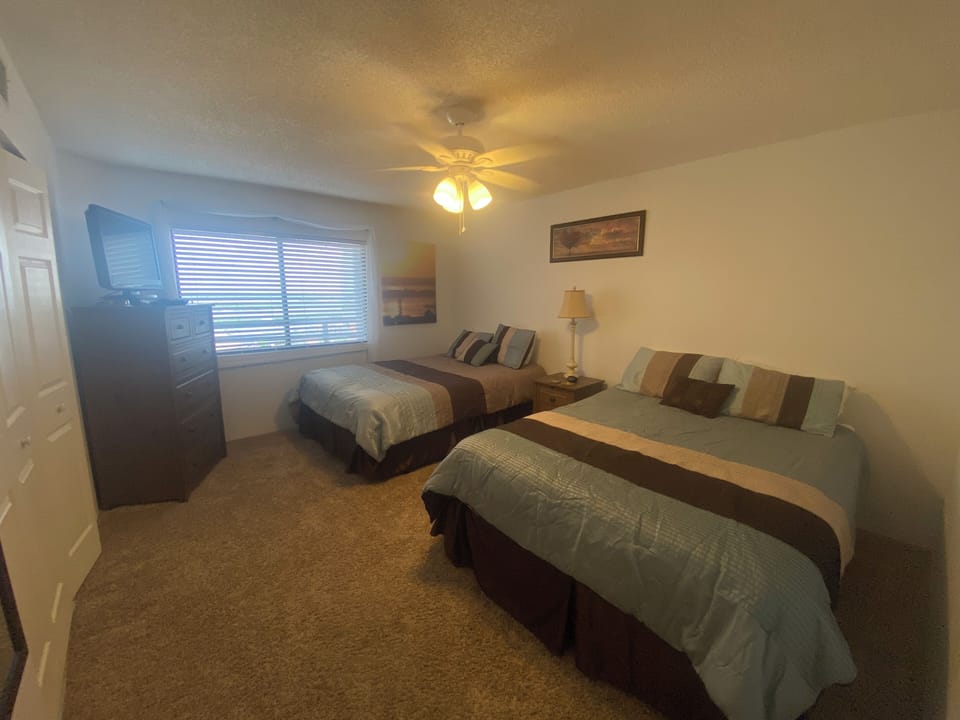 Guest room with river views, two full beds, TV and access to full bath.