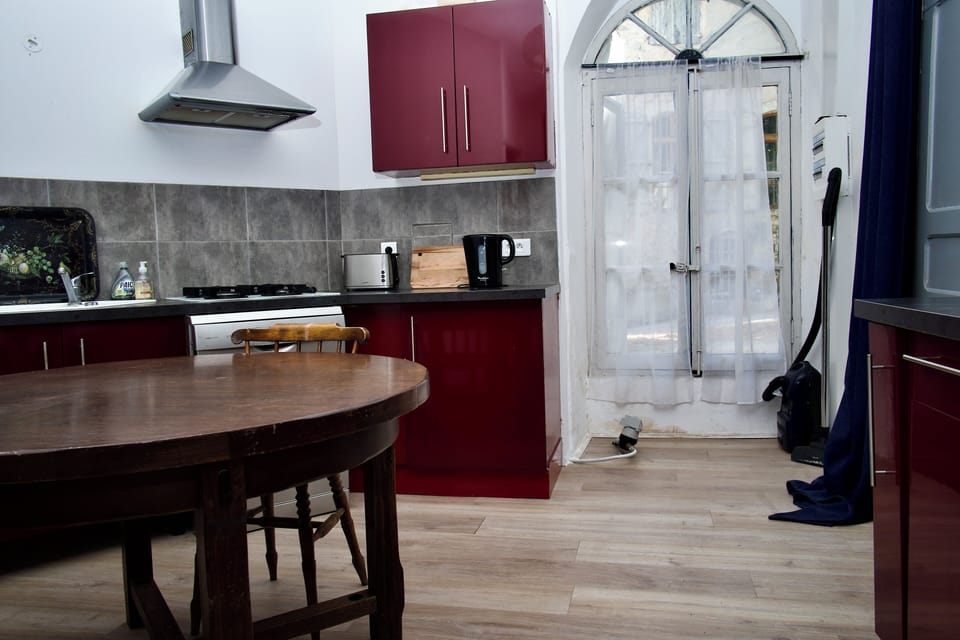 Kitchen with oven, gas stove,cockery and utensils.