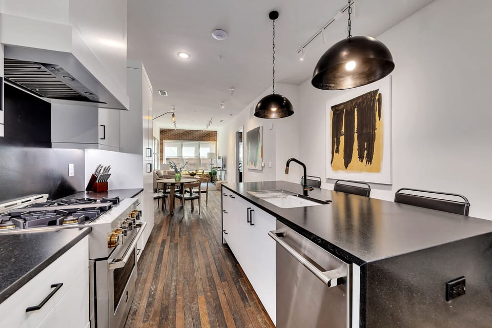 Contemporary kitchen island w/ bar seating & statement pendant lighting
