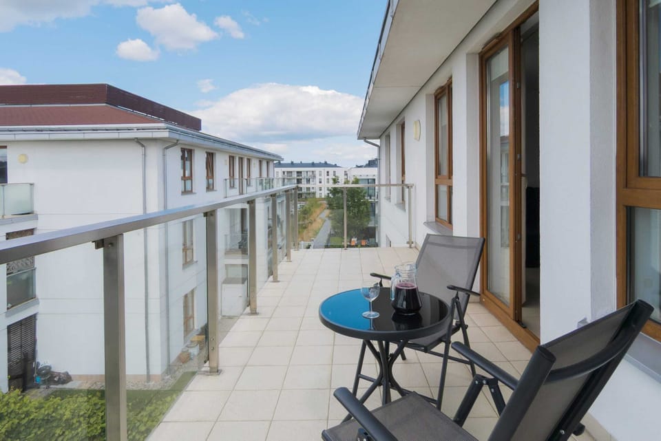 A spacious balcony with outdoor seating and beautiful views of the surrounding neighborhood, ideal for relaxing or enjoying coffee.