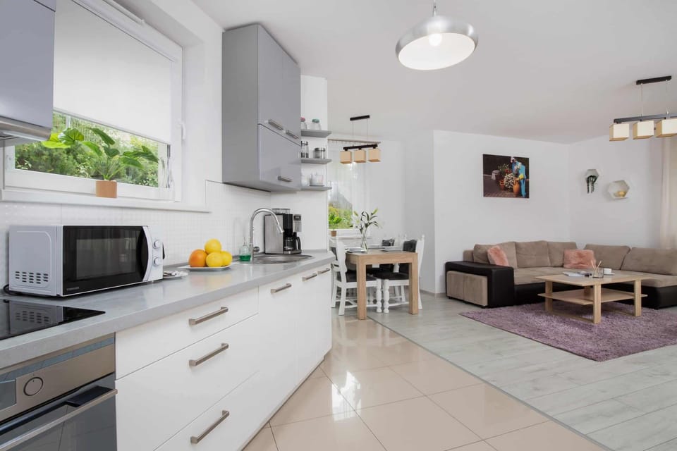 A modern kitchen with gray and white cabinets, a tiled backsplash, and essential appliances.