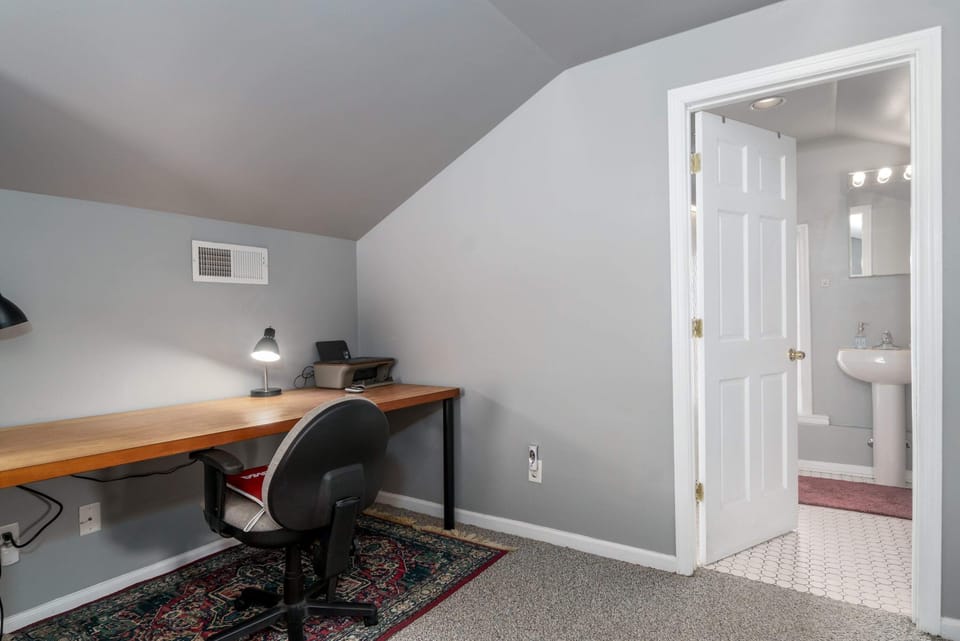 Work meets comfort in this bedroom, equipped with a desk, lamp, chair, and lightning-fast 500 Mbps internet.