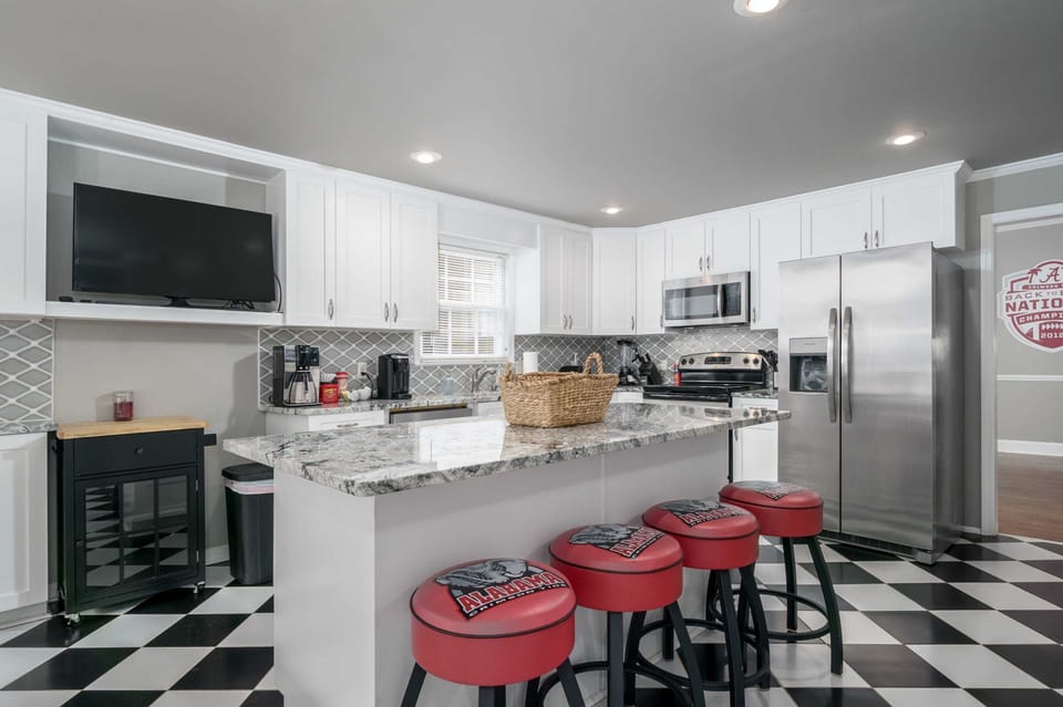 Roll Tide! This kitchen island bar features Alabama-themed stools, making every meal feel like a pre-game huddle for Crimson Tide fans.