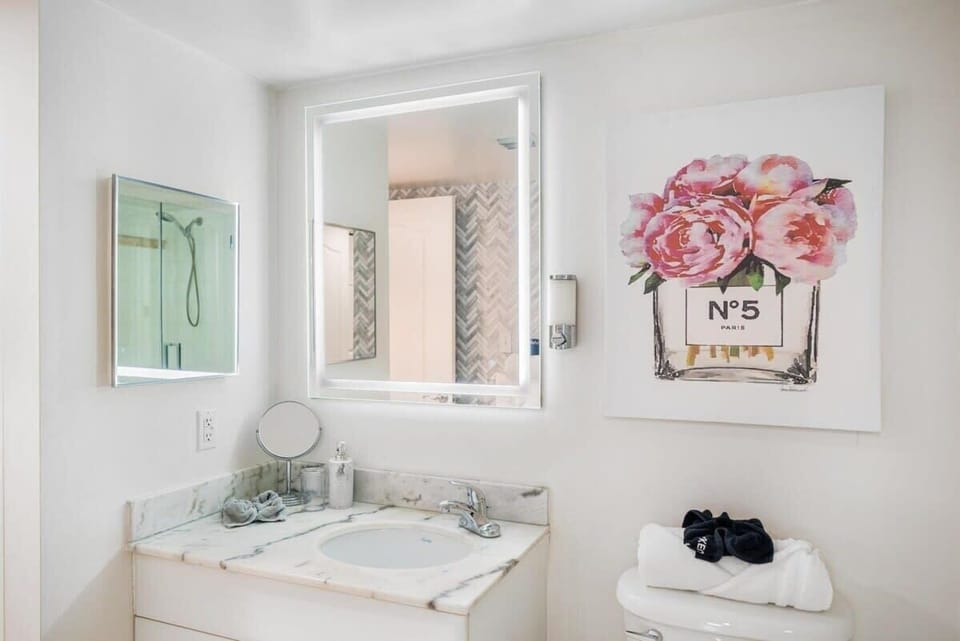 Modern bathroom with marble countertop and illuminated mirror