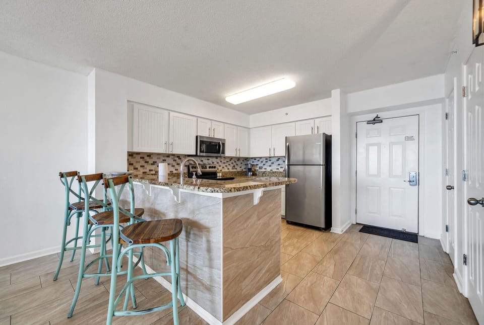 Your fully equipped kitchen awaits with granite countertops, stainless steel appliances, and a breakfast bar perfect for morning coffee.