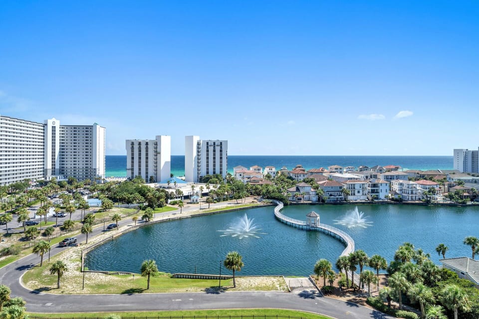 Stunning coastal community with elegant lagoon, fountains, and beachfront high-rises creating a perfect vacation paradise.