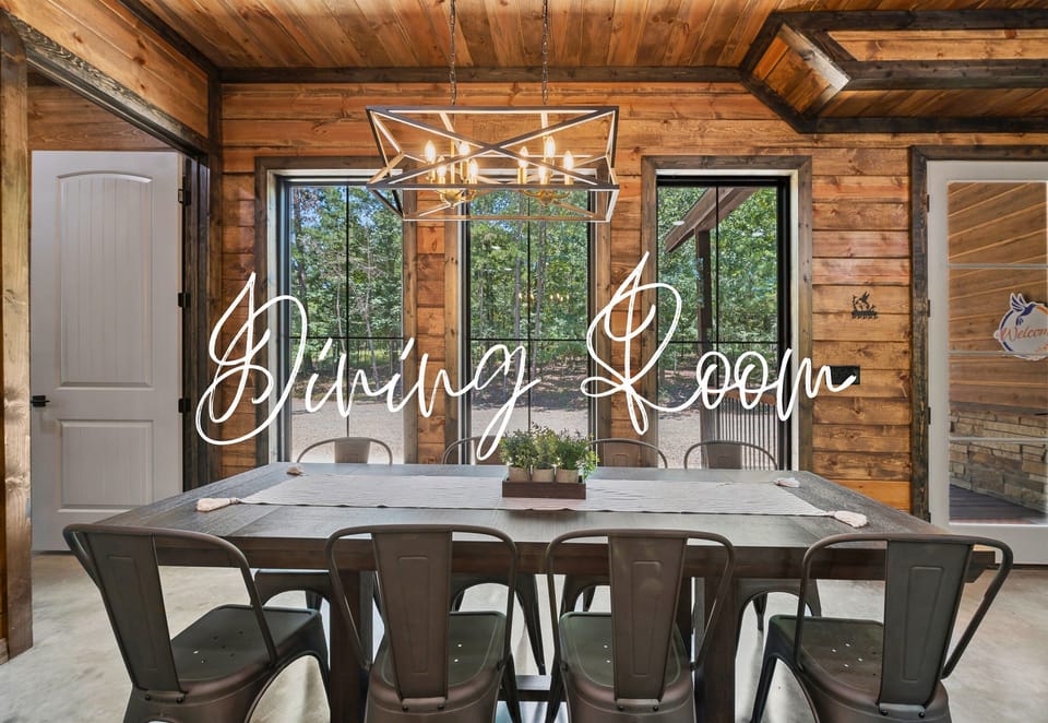 The dining room features a large wooden table with metal chairs, an artistic light fixture above, and a door leading outside