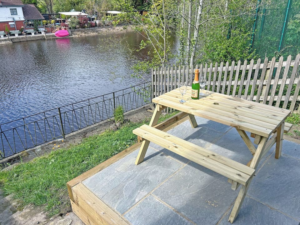 Patio and picnic table looking over the river | Chainbridge Cottage, Ruswarp, near Whitby