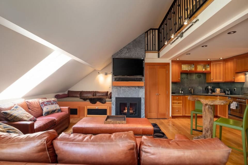 The unique living space features plenty of seating and a gorgeous fireplace and kitchen.