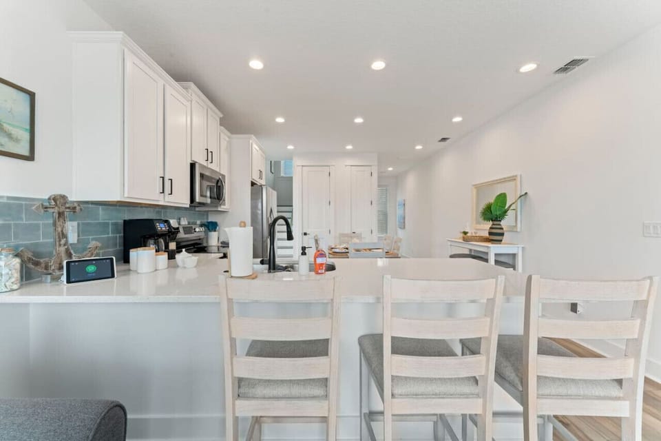 Open-concept kitchen with sleek new appliances, stocked with cookware and a drip/K-Cup coffee station. Enjoy casual meals at the bar or gather at the table.
