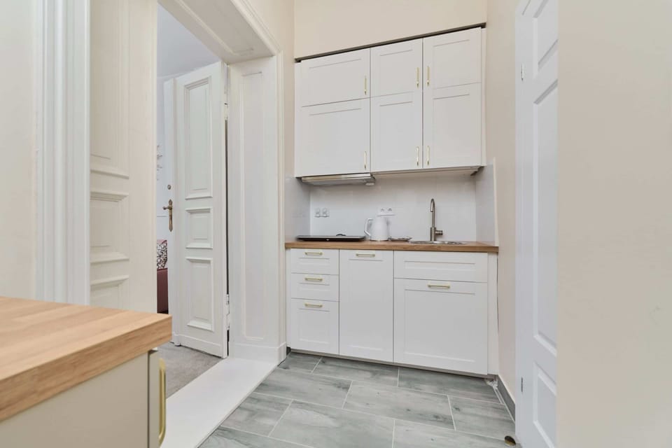 A minimalist white kitchen equipped with essential appliances, blending functionality with a polished design.