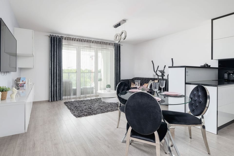 A bright and airy dining and living area, showcasing sleek furniture and a cozy environment for relaxation.

