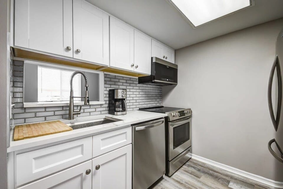 Modern kitchen with stainless steel appliances and white cabinetry