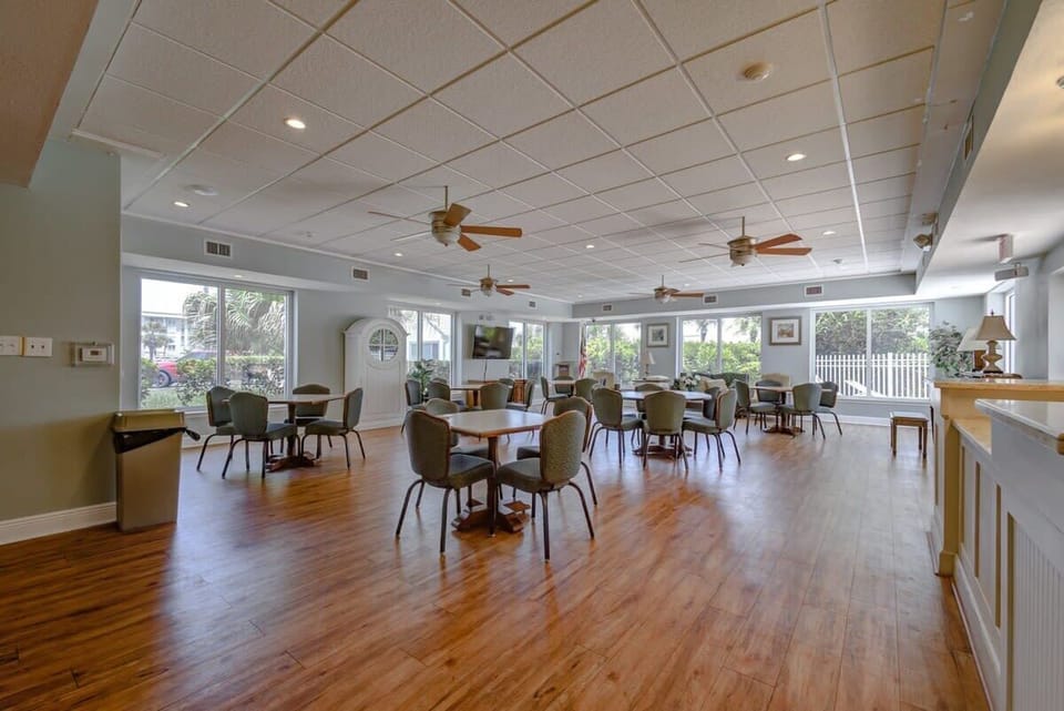 Spacious communal dining area with natural light and ceiling fans