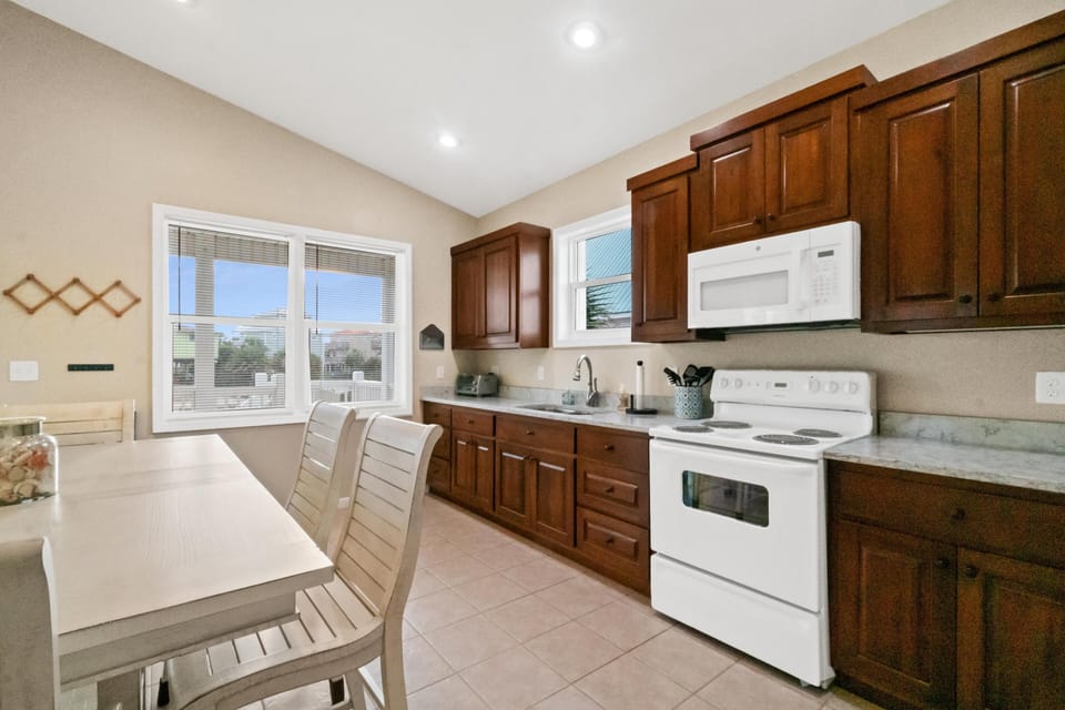 Your fully equipped kitchen features rich wood cabinets, modern appliances, and a cozy dining nook where you'll enjoy morning coffee.