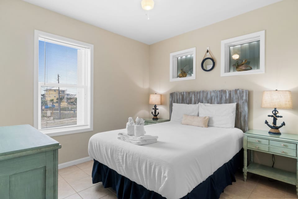 Drift off to peaceful sleep in your coastal-themed bedroom with crisp white linens and charming nautical touches.