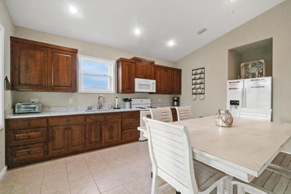 Your fully equipped kitchen awaits with rich wood cabinets, modern appliances, and a spacious island perfect for preparing meals together.