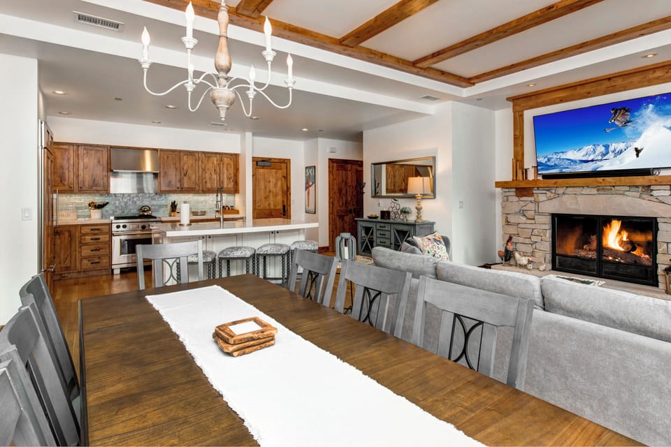 - Gather around the elegant dining table with mountain style chandelier above
- Enjoy the view of a crackling stone fireplace while seated for a shared meal
- Rustic wood cabinetry, quartz counters, and luxe finishes tie it all together