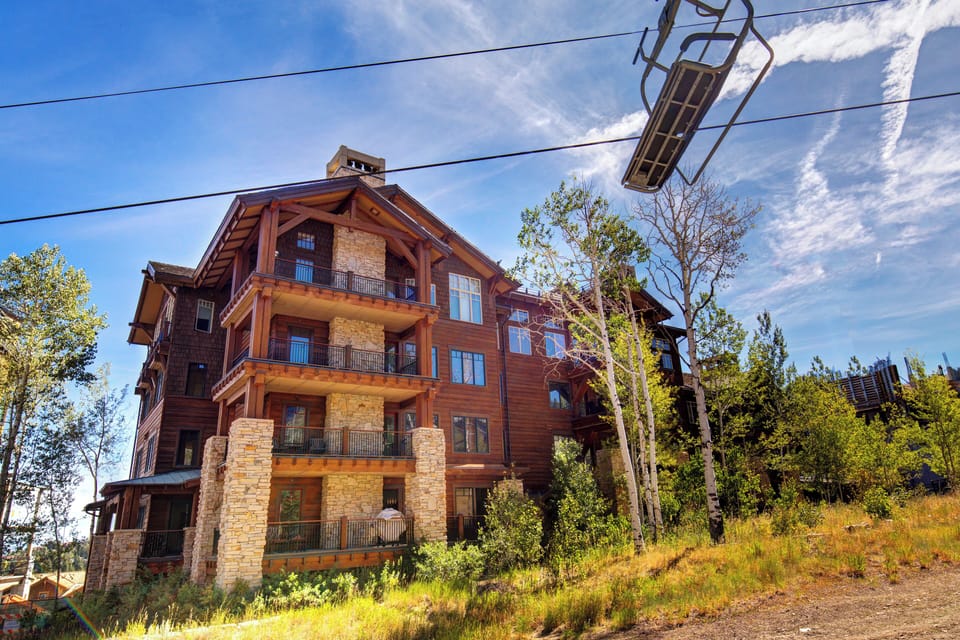 Rustic stone and timber facade sits just beneath the lift, steps from nature trails.