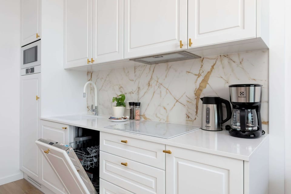 A modern kitchen with white cabinets, a round dining table, and a bright atmosphere.