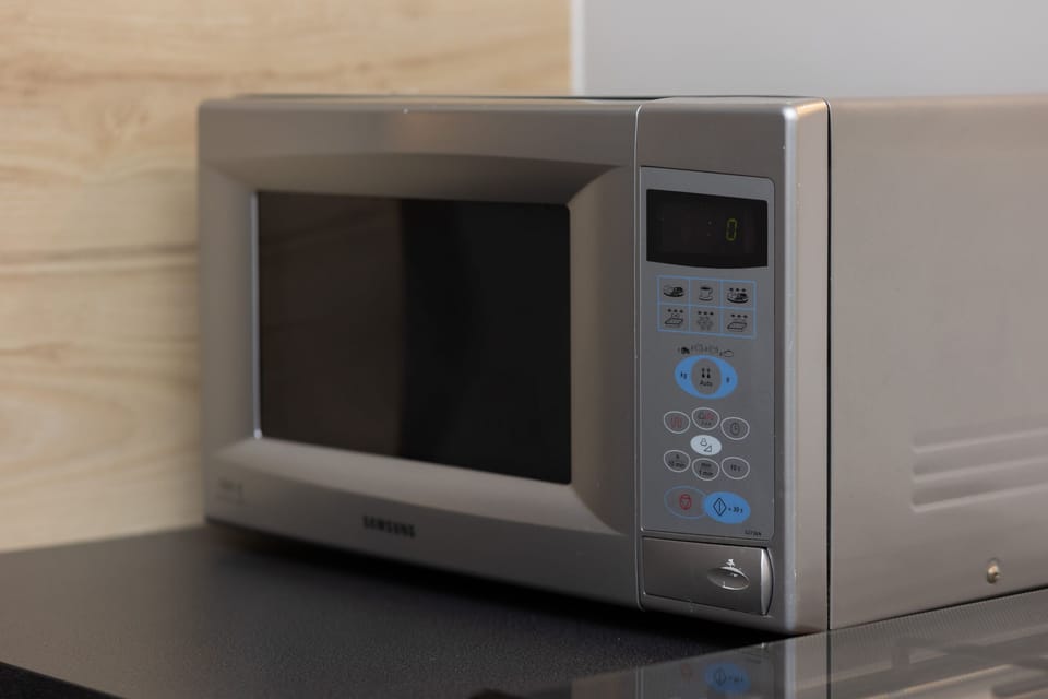 A close-up of a microwave, placed conveniently on a countertop as part of the kitchen amenities.

