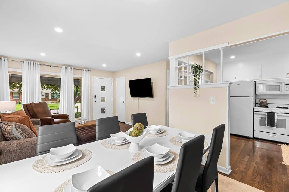The dining table is spacious enough to seat everyone comfortably, and the white dishes give the room a clean and modern look. 