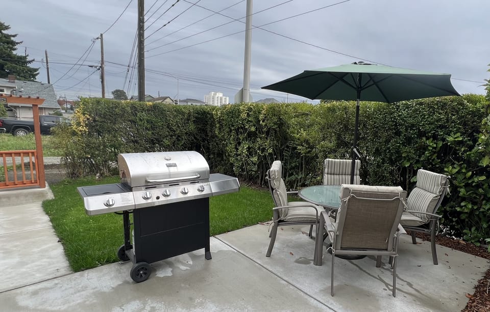 Relaxing patio with grill, table for 4 and 4 additional folding chairs.