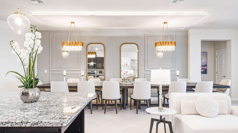 Elegant dining space with statement chandeliers, gold accents, and modern décor