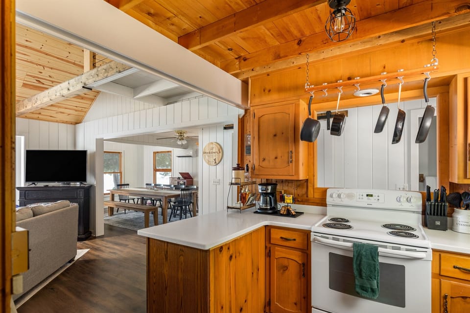 The fully equipped kitchen at The Dragonfly Cottage offers everything you need to prepare meals, with a cozy open layout connecting to the dining and living areas. Enjoy cooking while staying connected with family and friends.