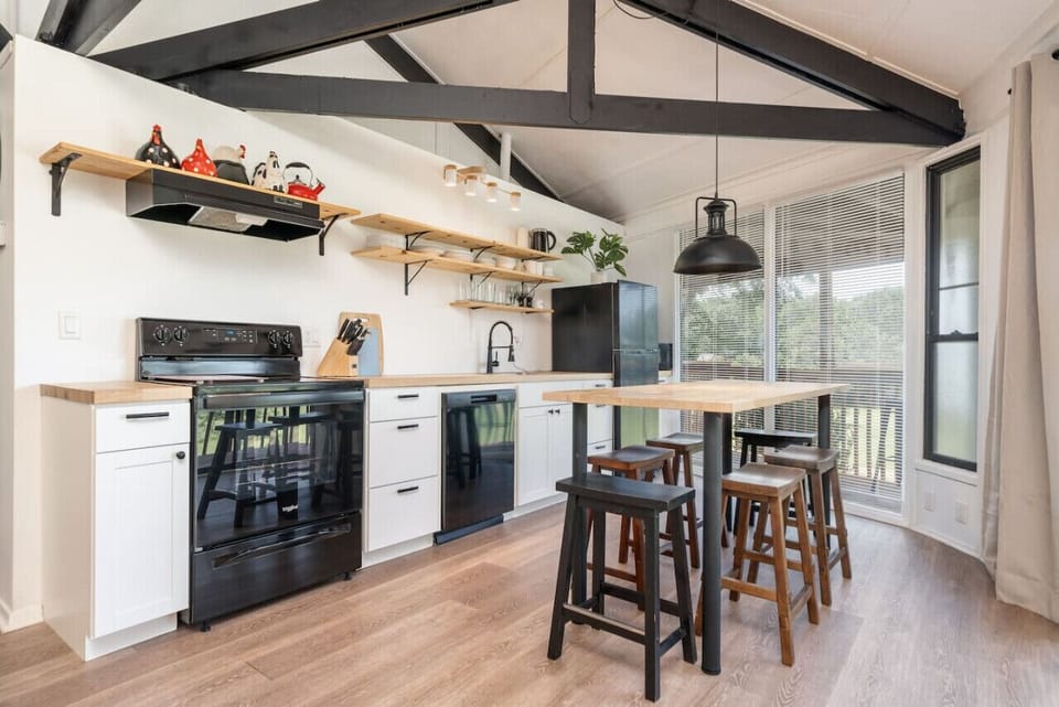 Open kitchen and dining area with modern touches, vaulted ceilings, and seating for four.