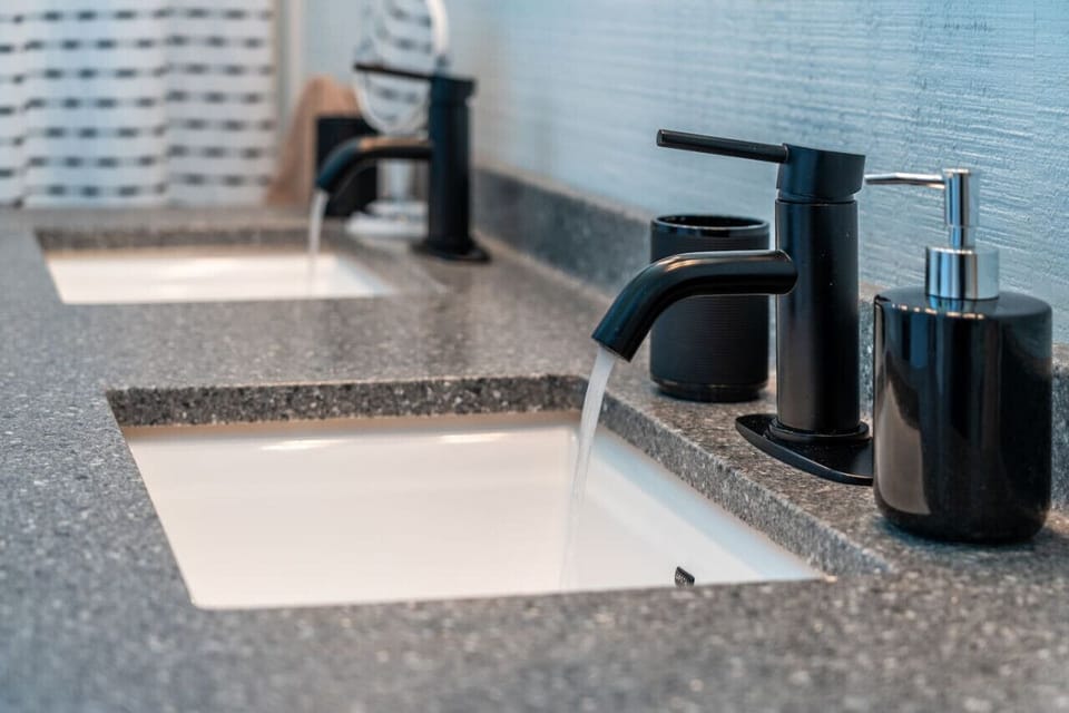 Sleek double-sink vanity with modern fixtures and essentials provided for your stay.