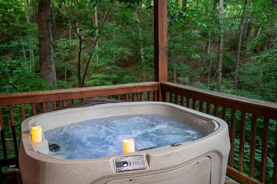 Hot tub on the lower-deck of the cabin with views of the hill-side forest. Photo facing southeast at dusk in the summer.