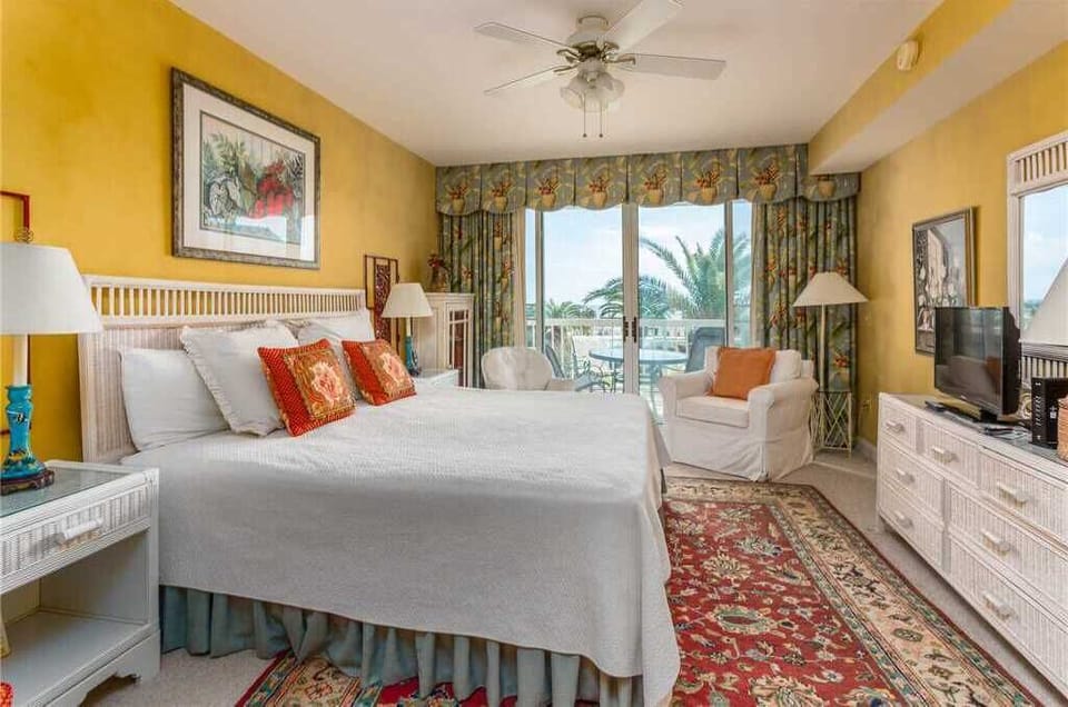 St. Simons Grand #113 King bedroom with ceiling fan and balcony access