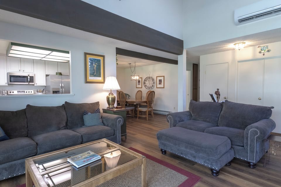 Spacious living room with high ceilings, dining area, and kitchen access