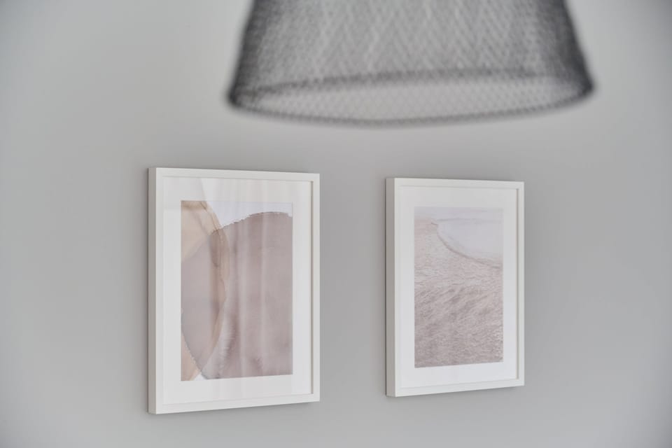 Minimalist wall art and soft gray tones enhance the apartment’s chic and calming aesthetic.

