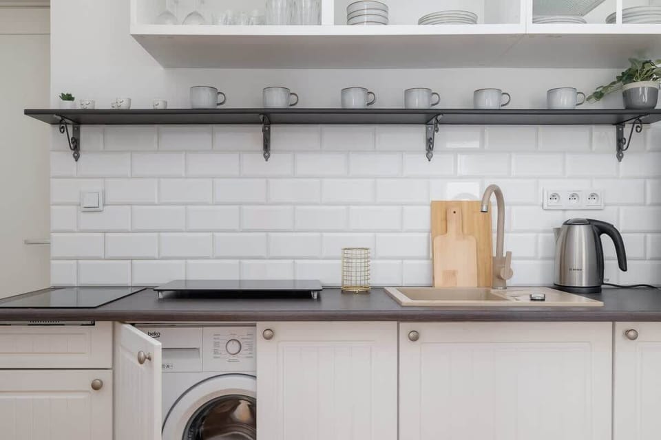 A sleek and modern kitchen with white cabinetry and a minimalist design.