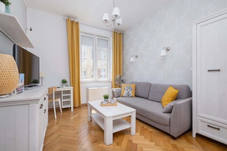 A cozy living area featuring a soft gray sofa adorned with decorative cushions.