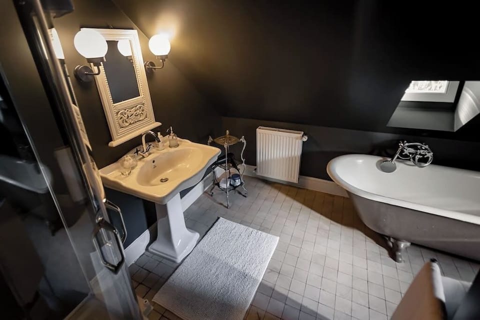 Bathroom with stand alone tub, walk in shower, toiletries and towels.