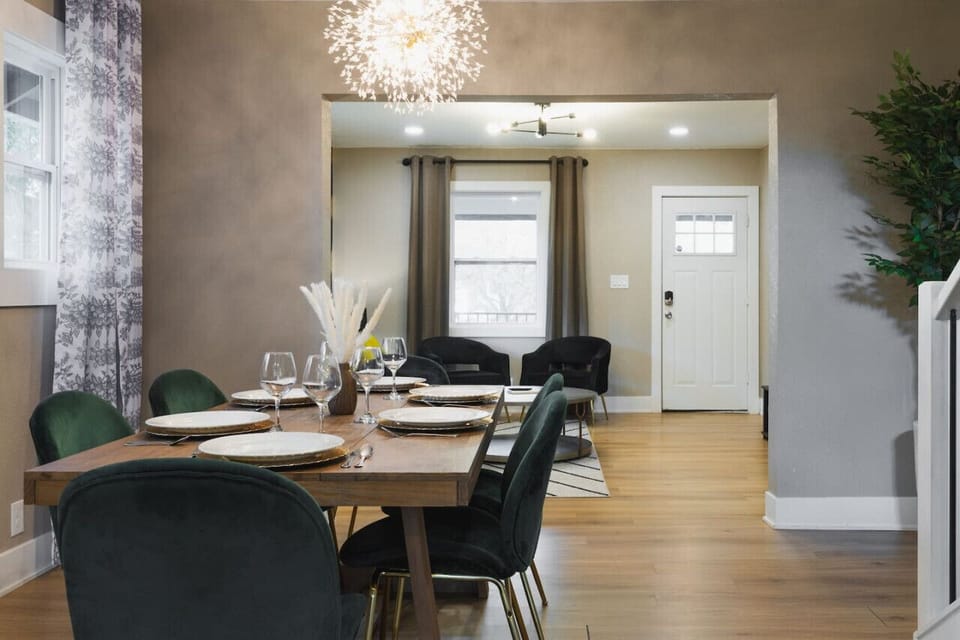 A spacious dining table awaits, surrounded by warm tones and elegant lighting for a welcoming atmosphere.