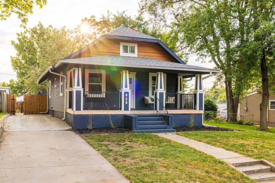 This cheerful home welcomes you with a spacious front porch and a charming lawn, perfect for relaxing outdoors.