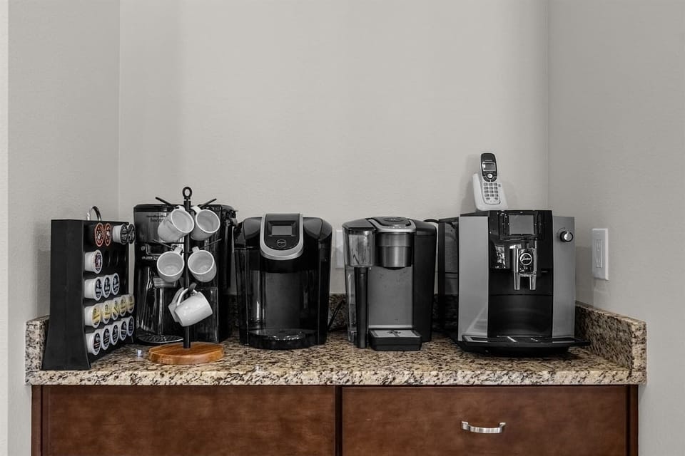 Convenient coffee station featuring multiple coffee machines, perfect for large groups, with a selection of limited coffee pods to enjoy fresh brews throughout your stay.