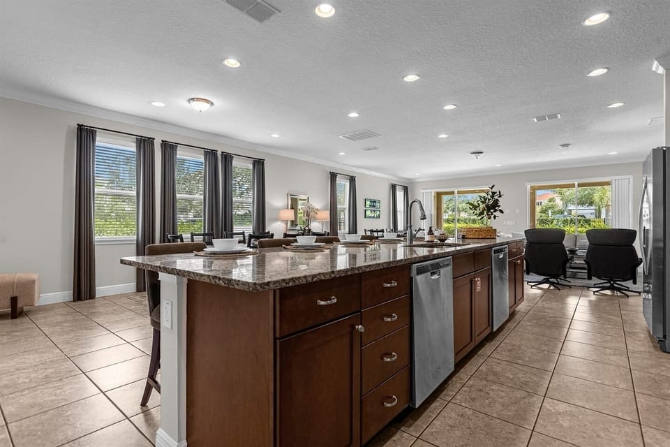 Gourmet kitchen featuring modern appliances, two refrigerators, and a spacious island with ample seating, perfect for culinary adventures and social gatherings.