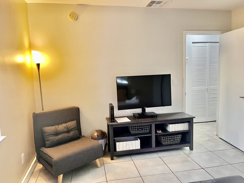 Inside the main bedroom a large tv,a small sofa bed accommodates a small person.