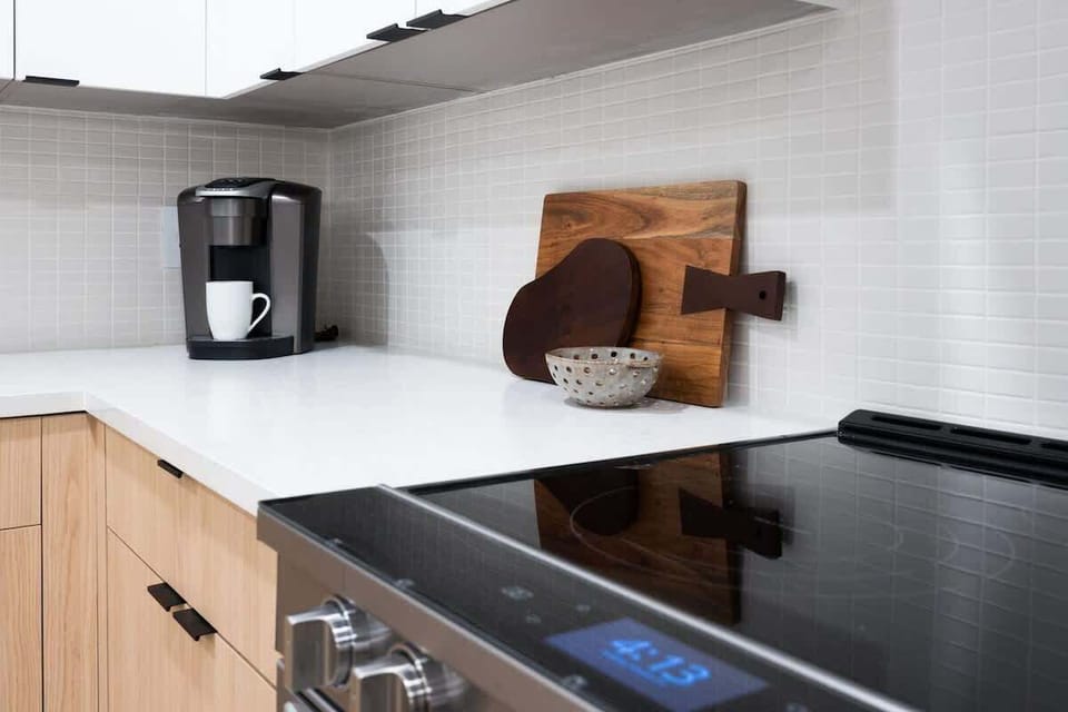 Fully equipped kitchen boasting stainless-steel appliances and an island offering bar seating. Kitchen fully stocked with all culinary essentials for ease and convenience.