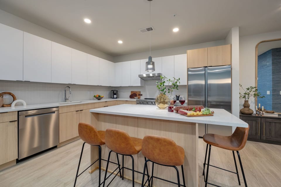 Fully equipped kitchen boasting stainless-steel appliances and an island offering bar seating. Kitchen fully stocked with all culinary essentials for ease and convenience.